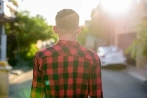 Joven camina solo por la calle al atardecer, representando la independencia y la pensión alimenticia tras la mayoría de edad.